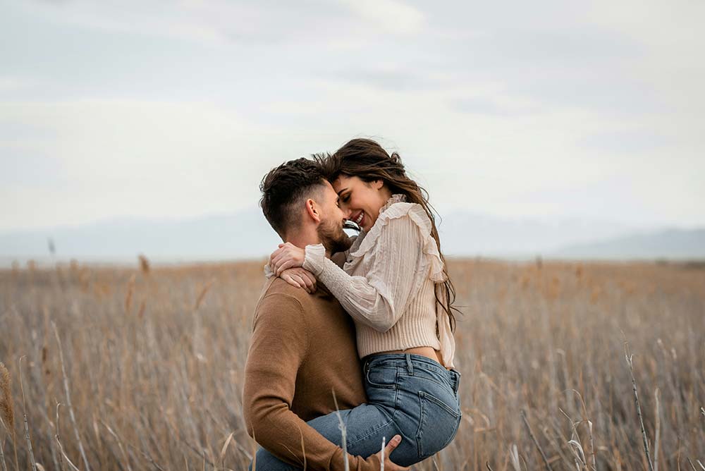 A Man Holds a Woman in a Field