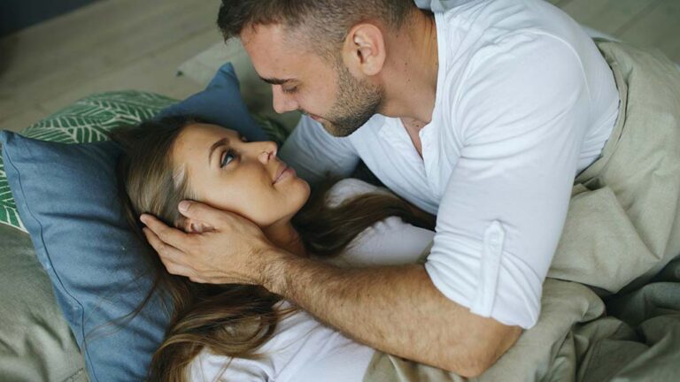 Couple looking at each other in bed
