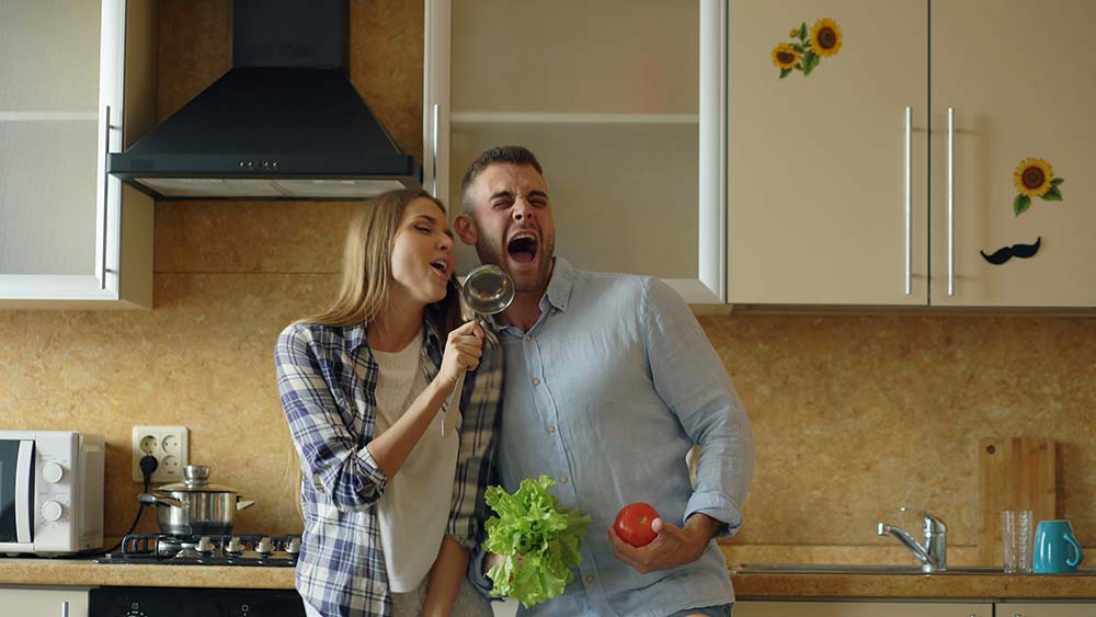 Couple singing together in the kitchen