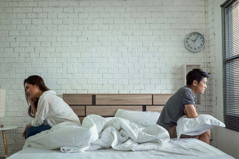 asian couples quarrel sit in bed
