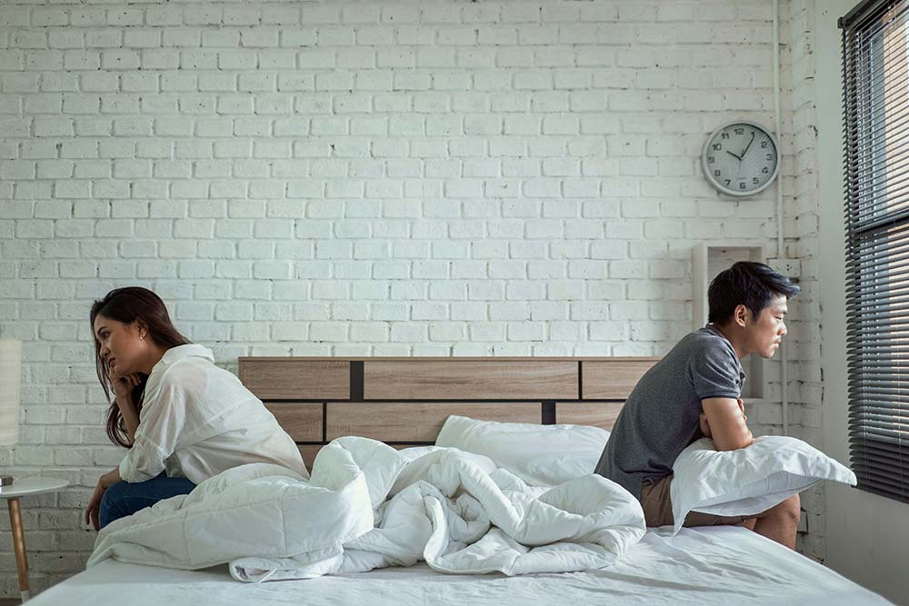 asian couples quarrel sit in bed