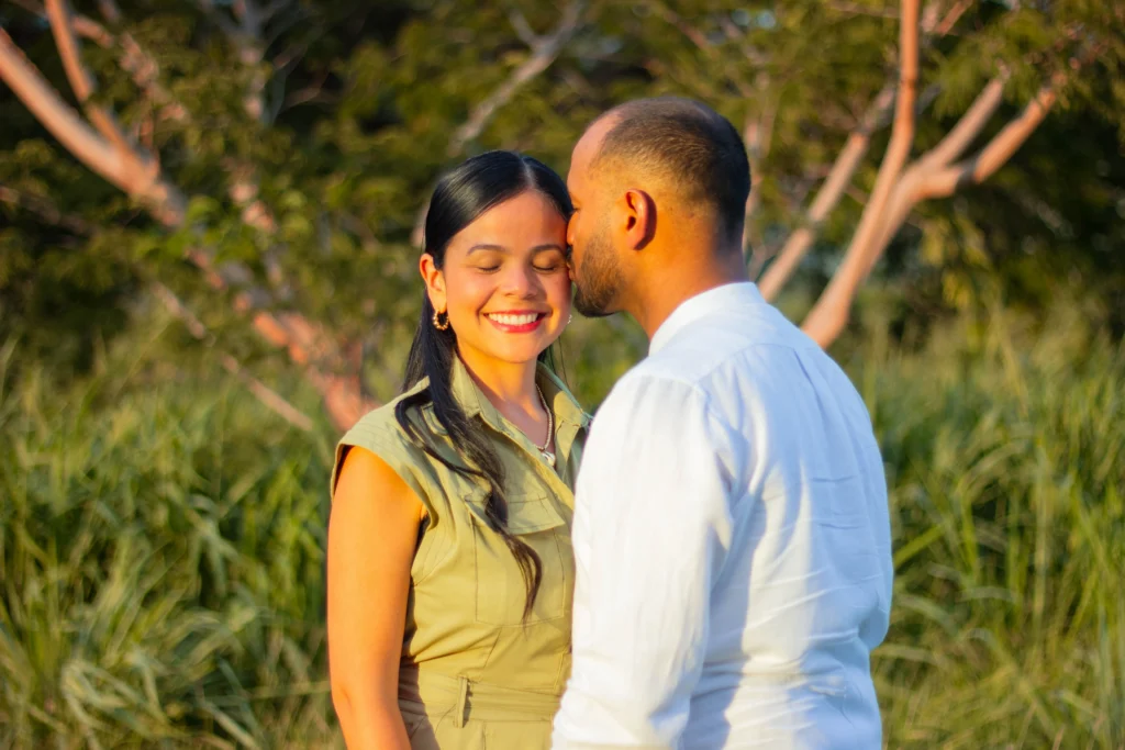 Couple smiling outdoors in a natural setting, ideal for relationship coaching and wellness
