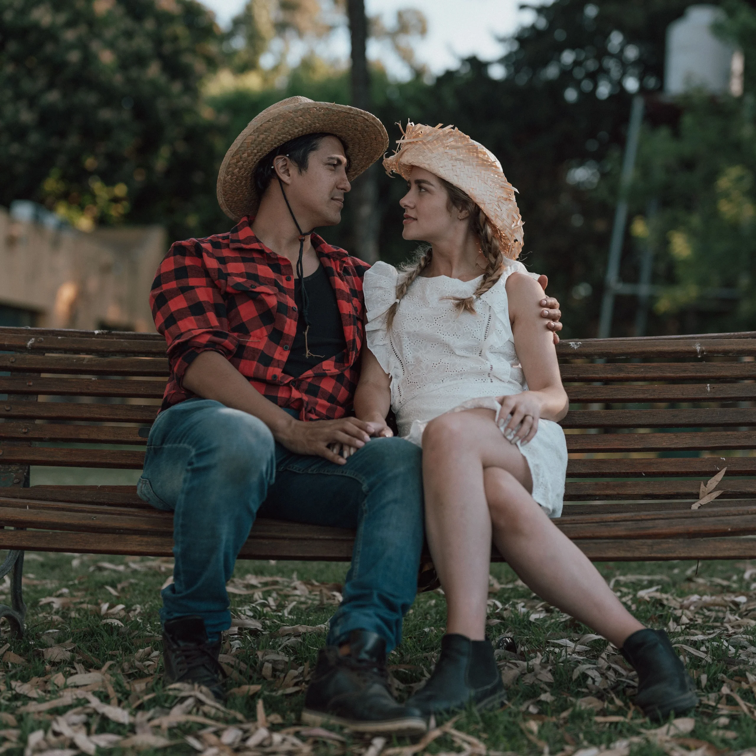 A couple wearing straw hats sitting together