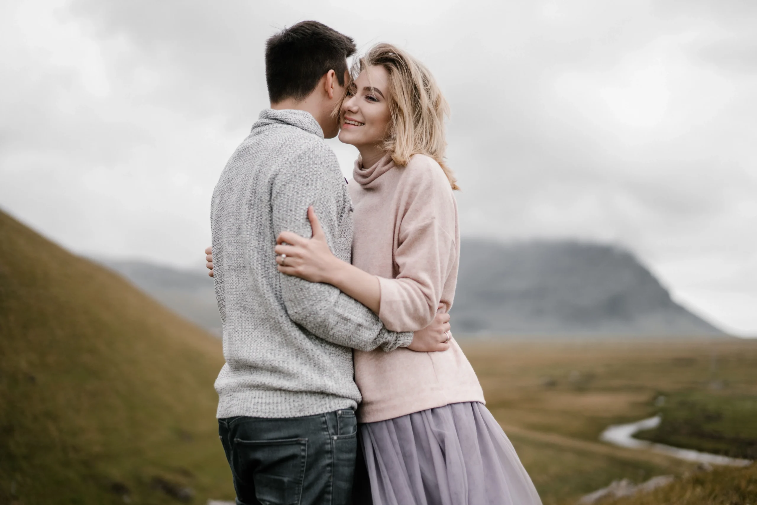 Couple hugging on a misty hillside, capturing a serene and romantic